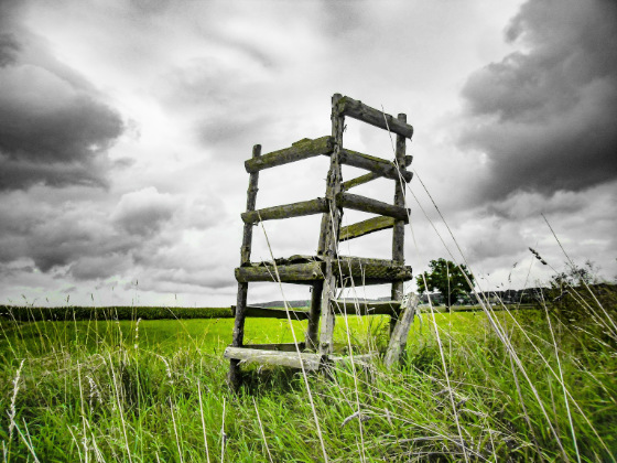 Decaying chair with dramatic clouds